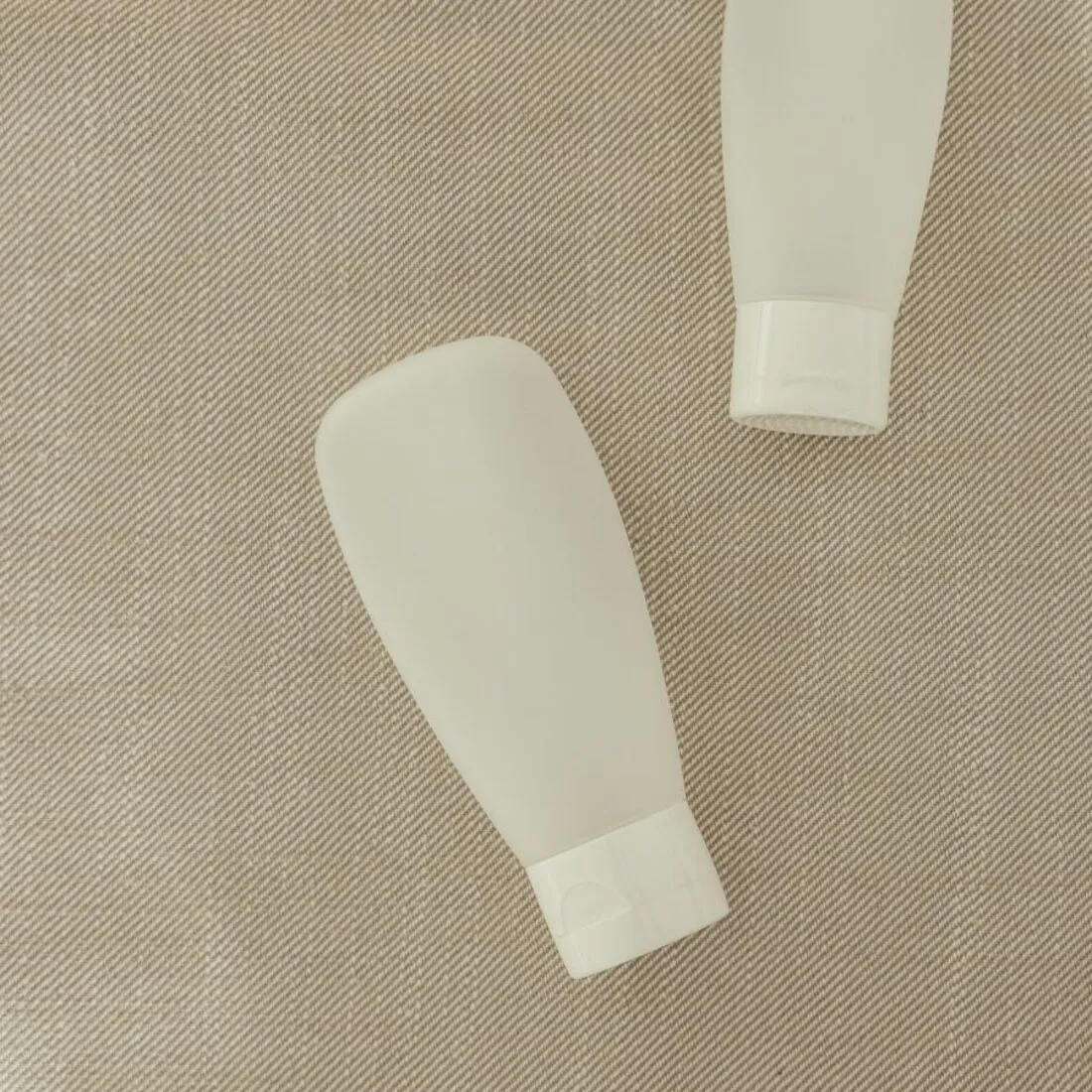 Envases de viaje de cosmética sobre tela de lino