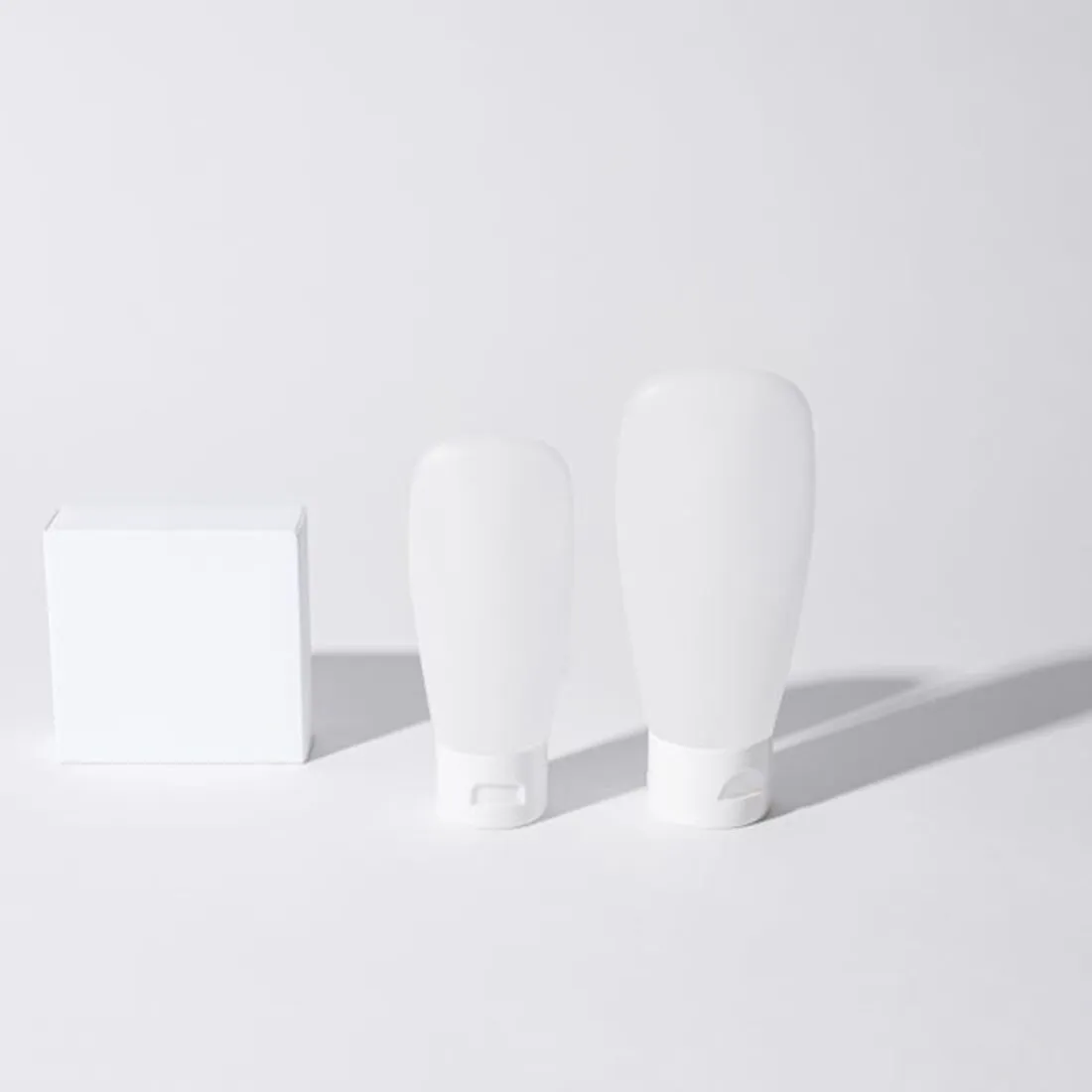 Frascos blancos de cosmética sobre fondo gris claro